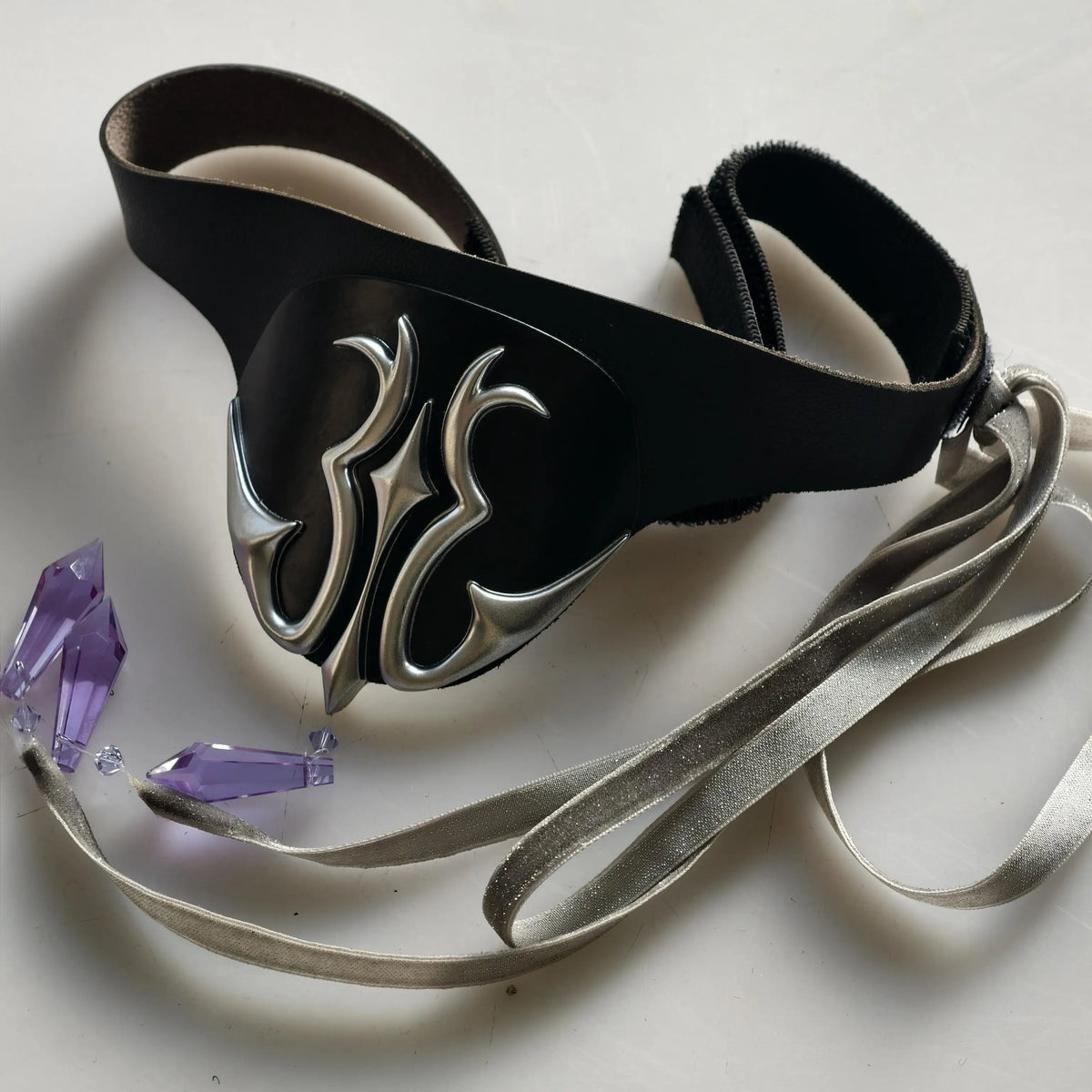Black eye mask with silver flame emblem and satin ribbon ties