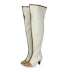 Knee-high white boots with gold trim, pointed toe, and mid block heel