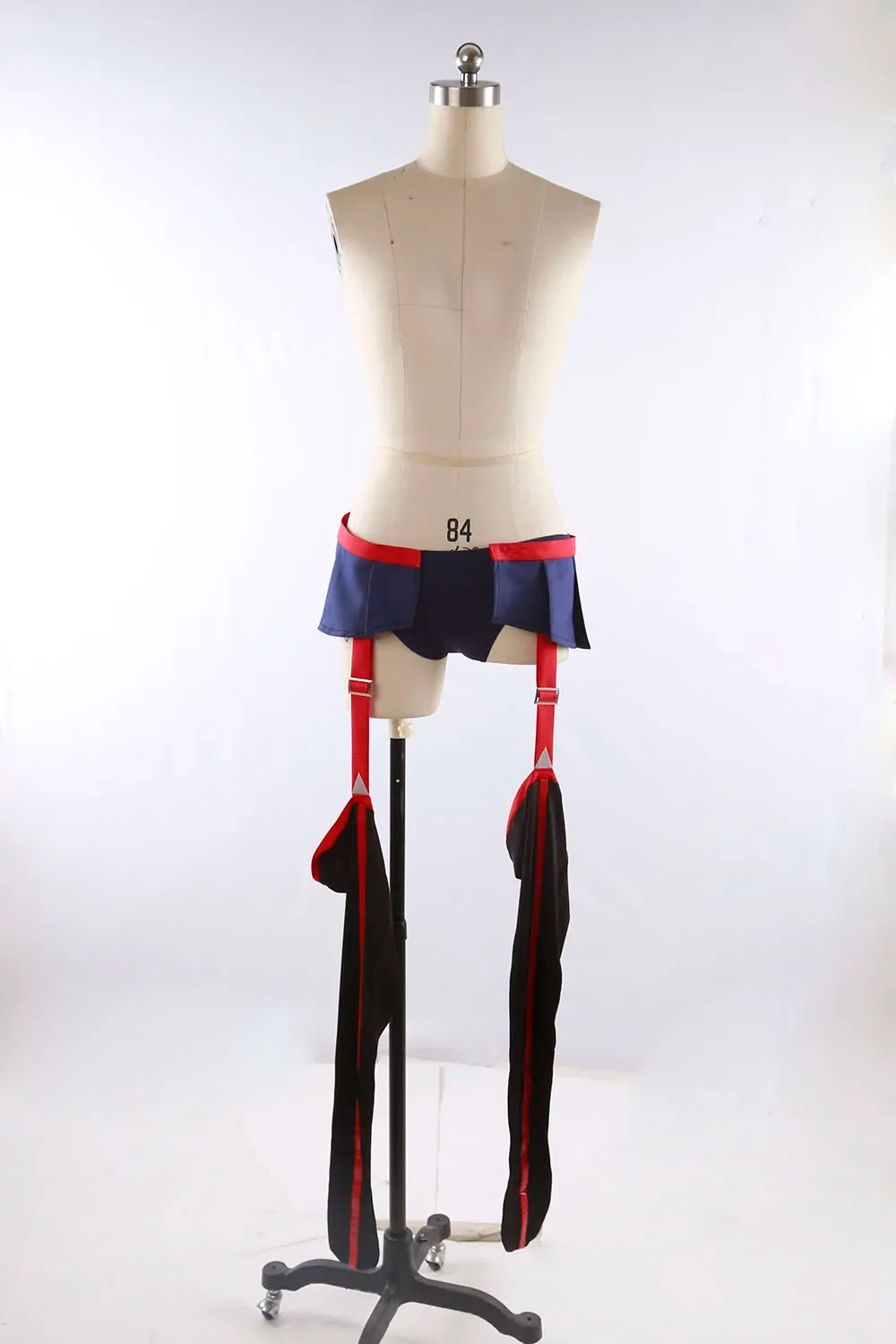 Cosplay costume on mannequin, lower view: navy waistband skirt with red trim and black thigh panels