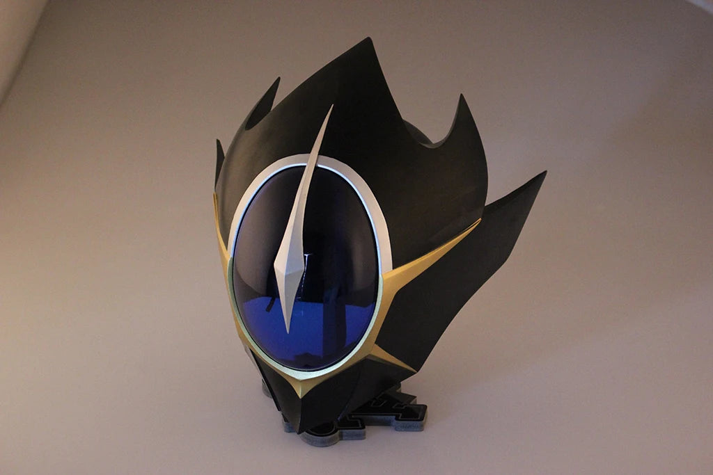 Black cosplay helmet with blue visor and silver frame, gold accents on a display base